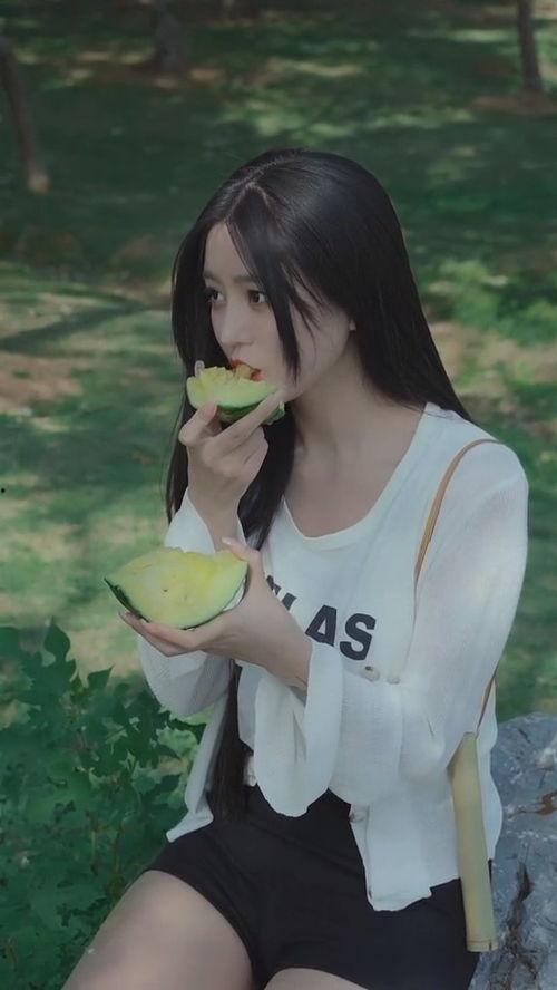 美女在路边吃瓜,夏日风情尽收眼底
